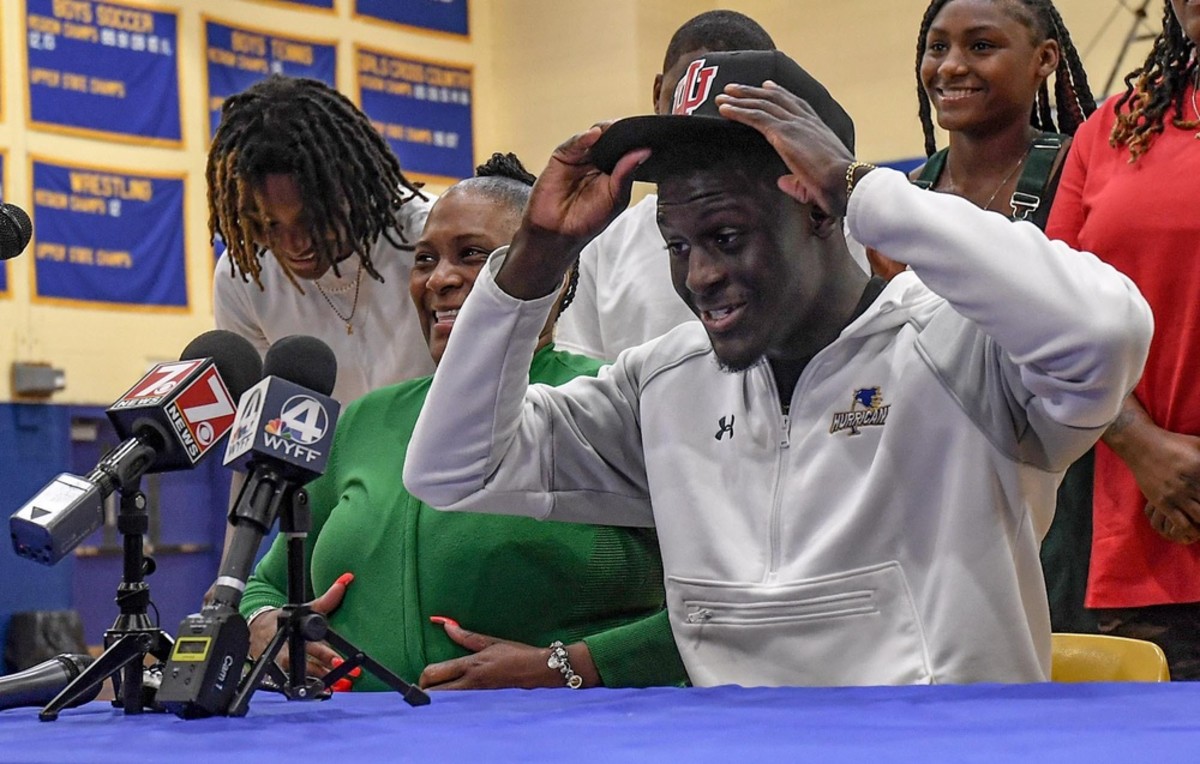 Travon West puts on an Indiana hat as he announces his commitment to become a Hoosier at Wren High School in Piedmont, S.C on Wednesday, June 29.